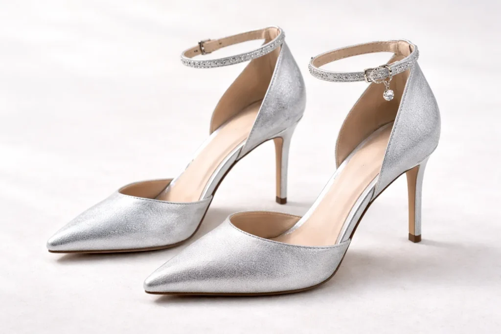 Pair of elegant silver heels with ankle straps on a white background